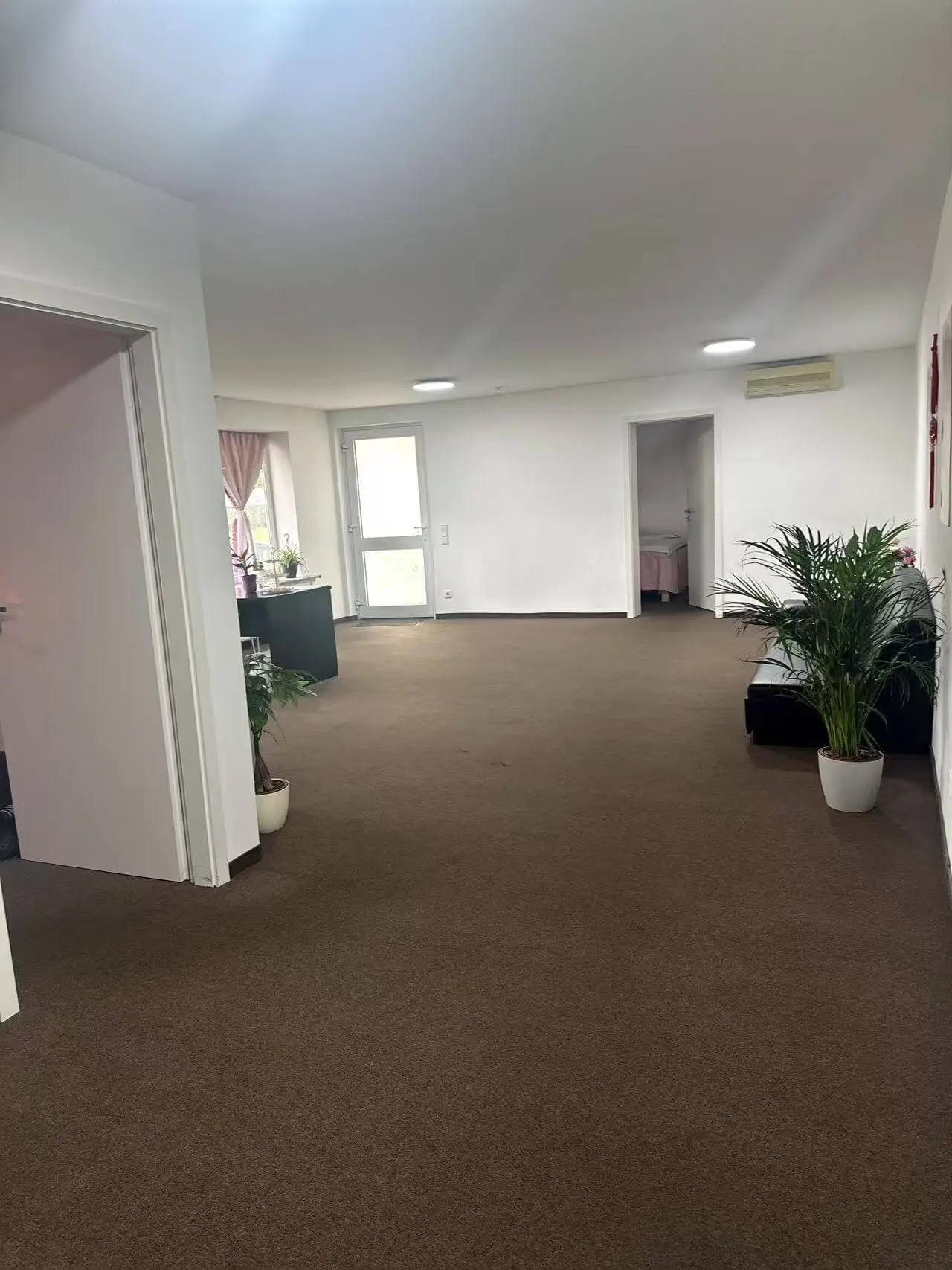 Behandlungsraum mit rosa Dekoration und Massageliege